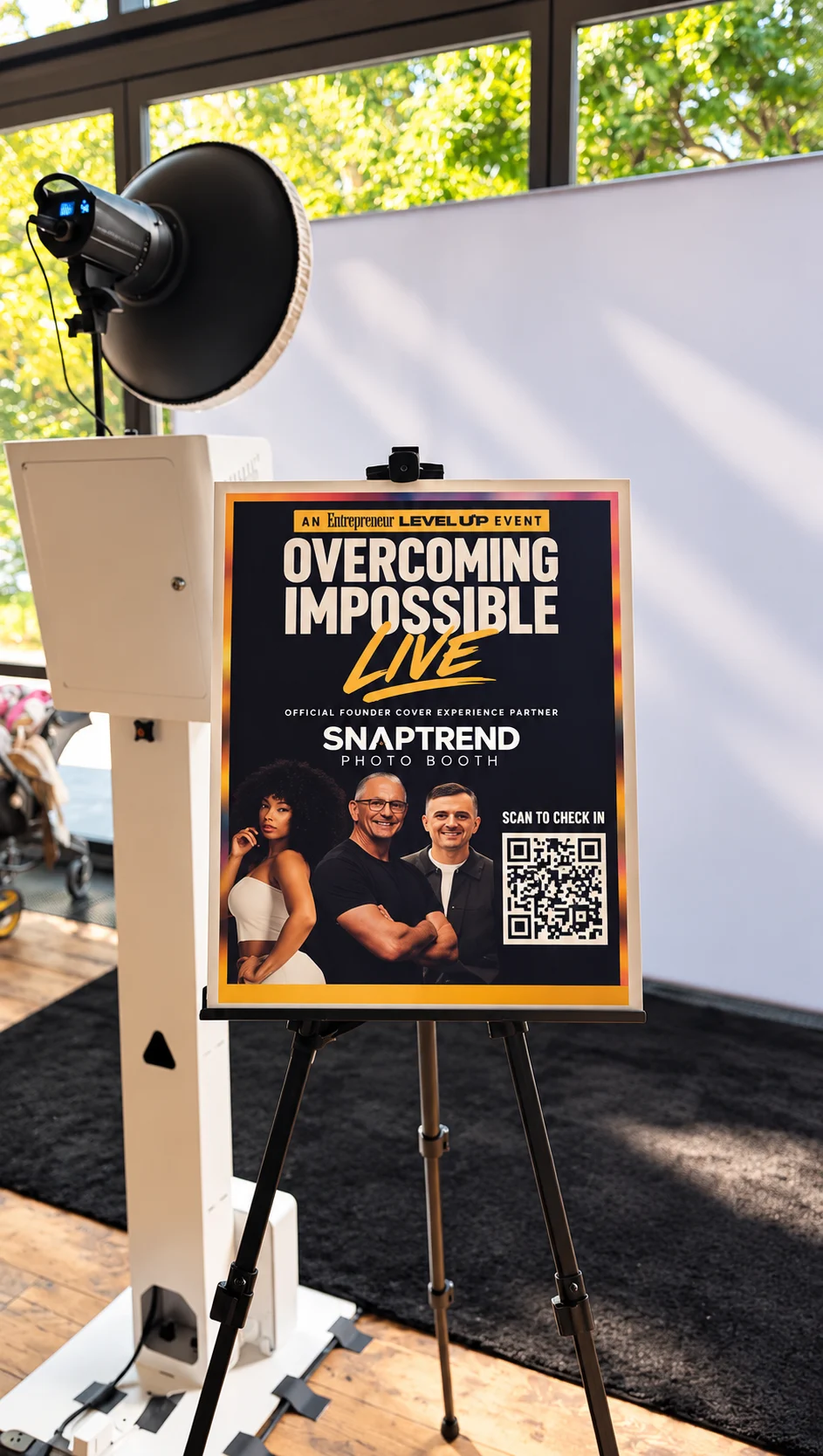 Snaptrend portrait booth, studio lighting, and Entrepreneur event sign with a Scan to Check In QR code