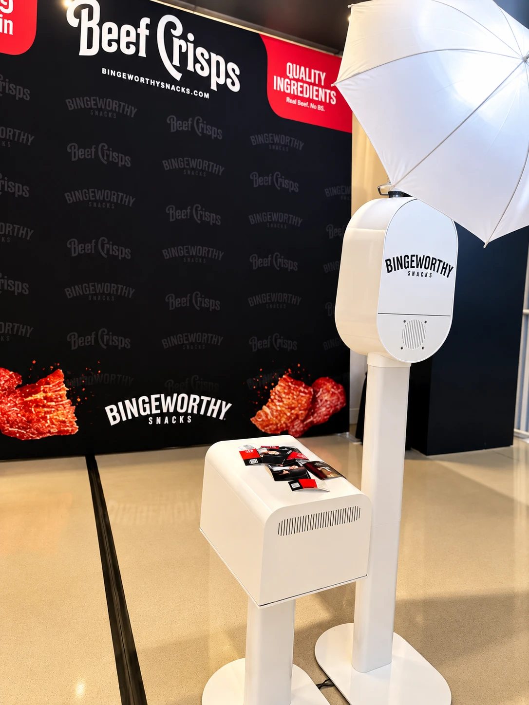 Supplied reference photo of a branded photo booth and printer at an event activation