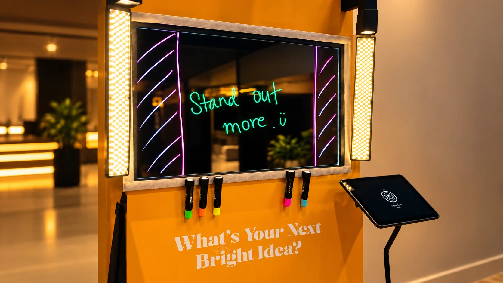 Scribble Booth setup with illuminated glass, colorful markers and a touchscreen preview.