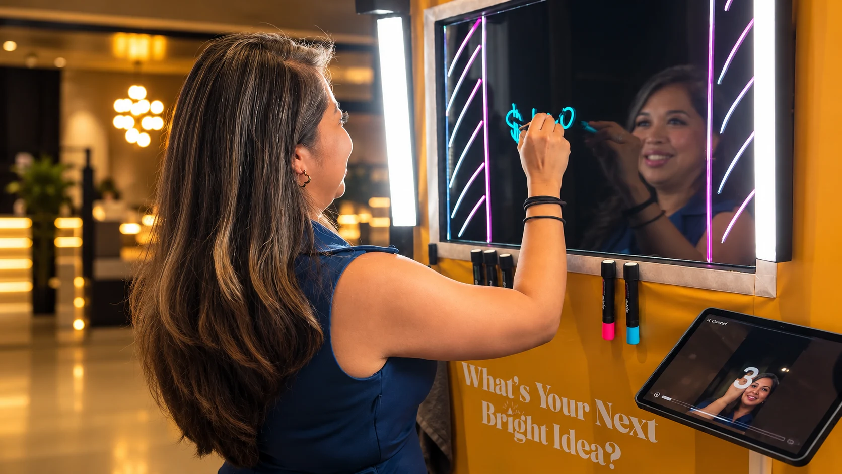 Guest writing on Snaptrend’s illuminated Scribble Booth glass canvas.