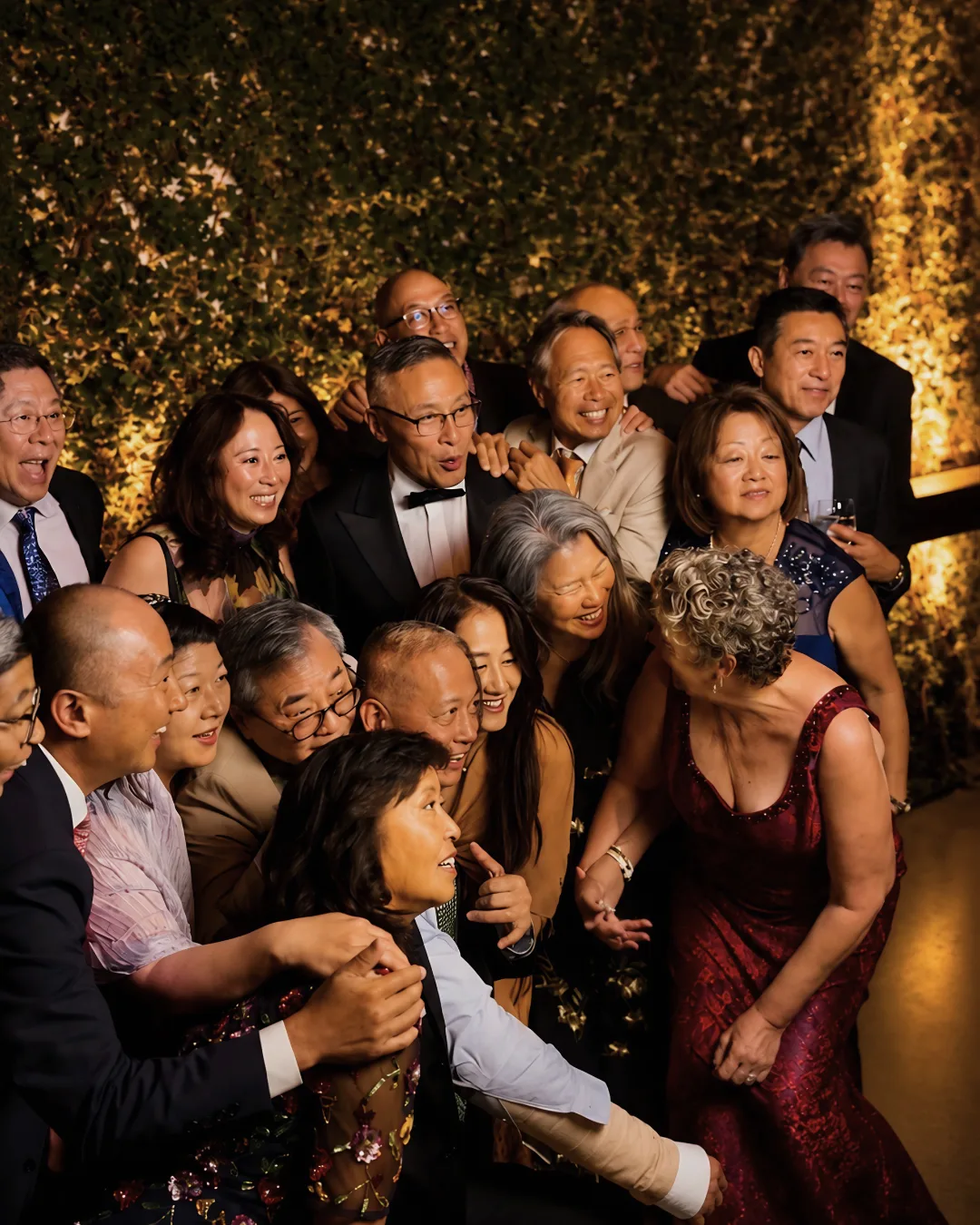 Wedding guests crowd together for a lively group photo