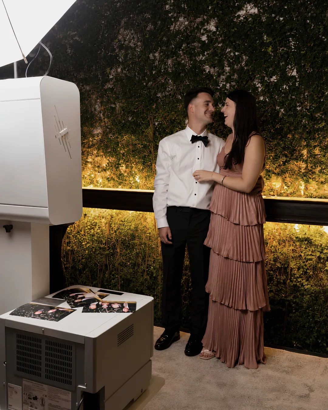 Two guests pose by the photo booth and umbrella light
