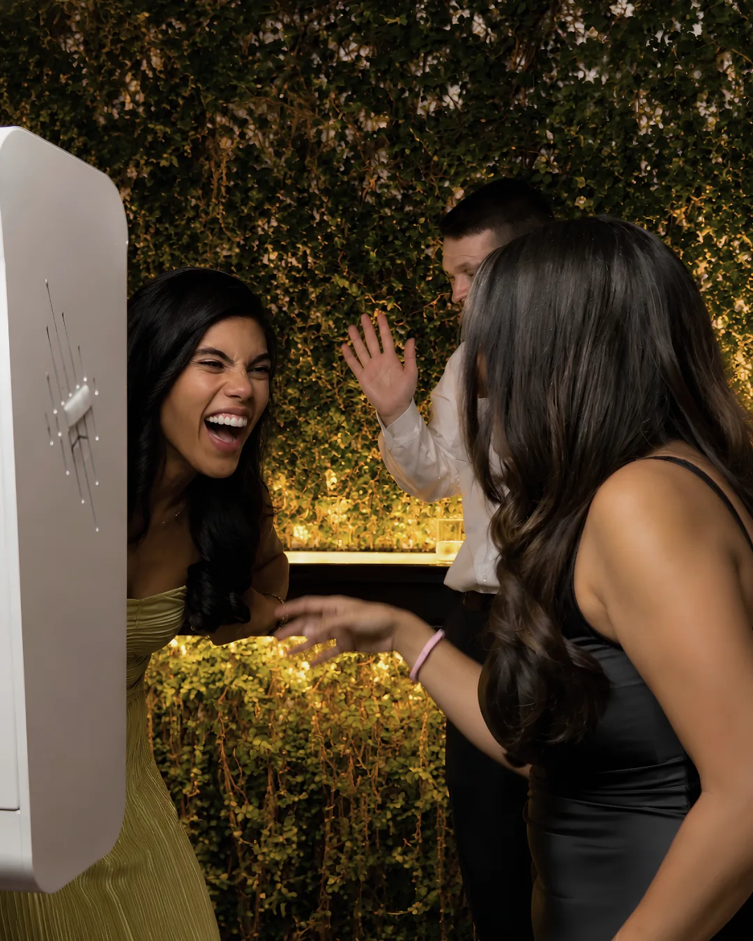 Two guests laugh at the photo booth