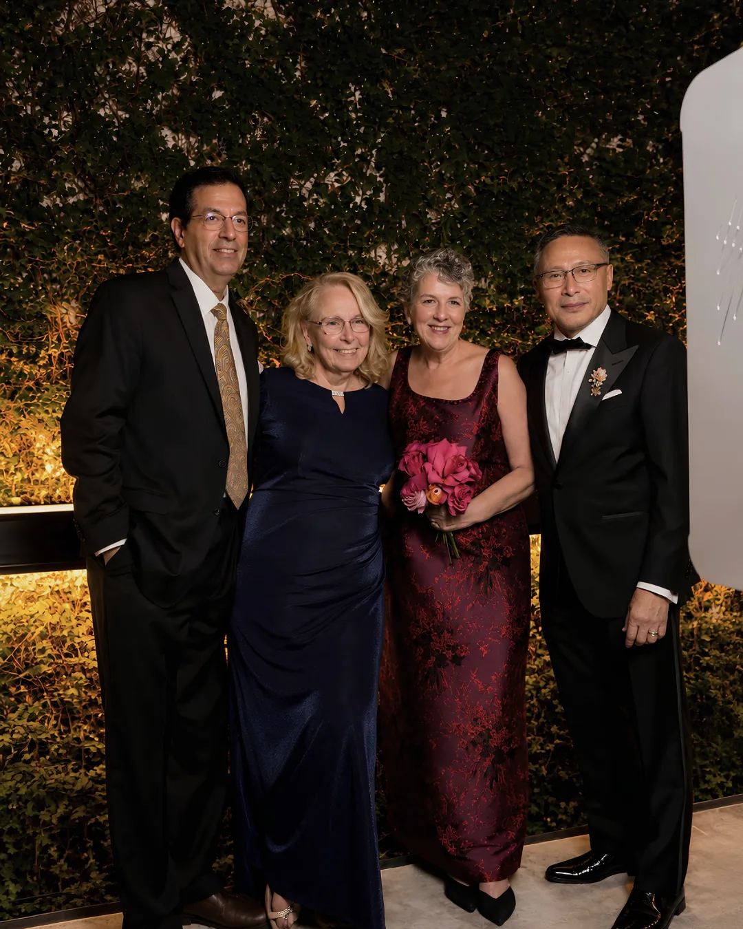 Four wedding guests pose for a portrait together