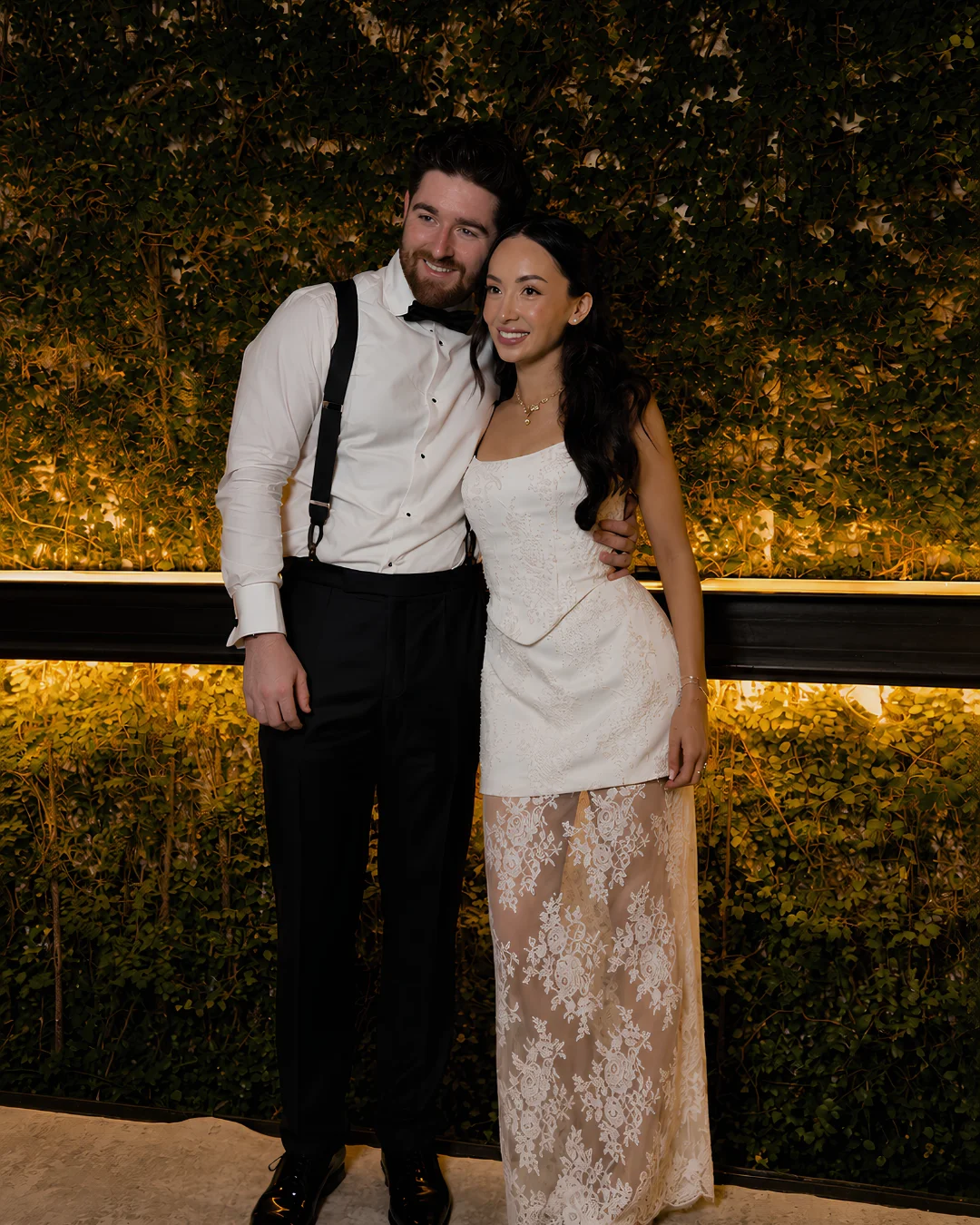 Catherine and Lorcan together in front of the greenery at their wedding