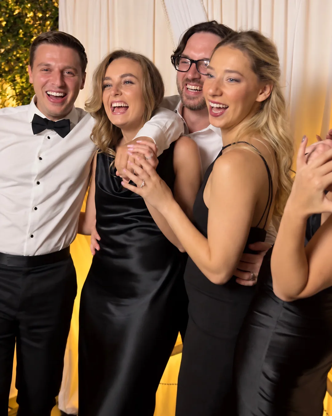 Four guests laugh and pose for a photo