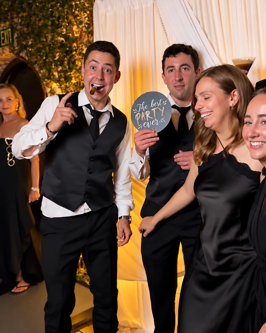 Guests hold a playful prop while posing at the booth
