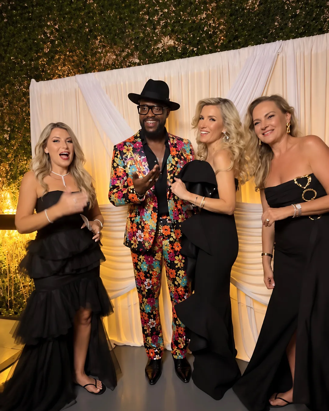 Wedding guests pose together with a colorful hat and jacket