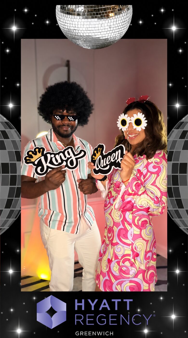 Guests posing with disco-themed props for a party portrait