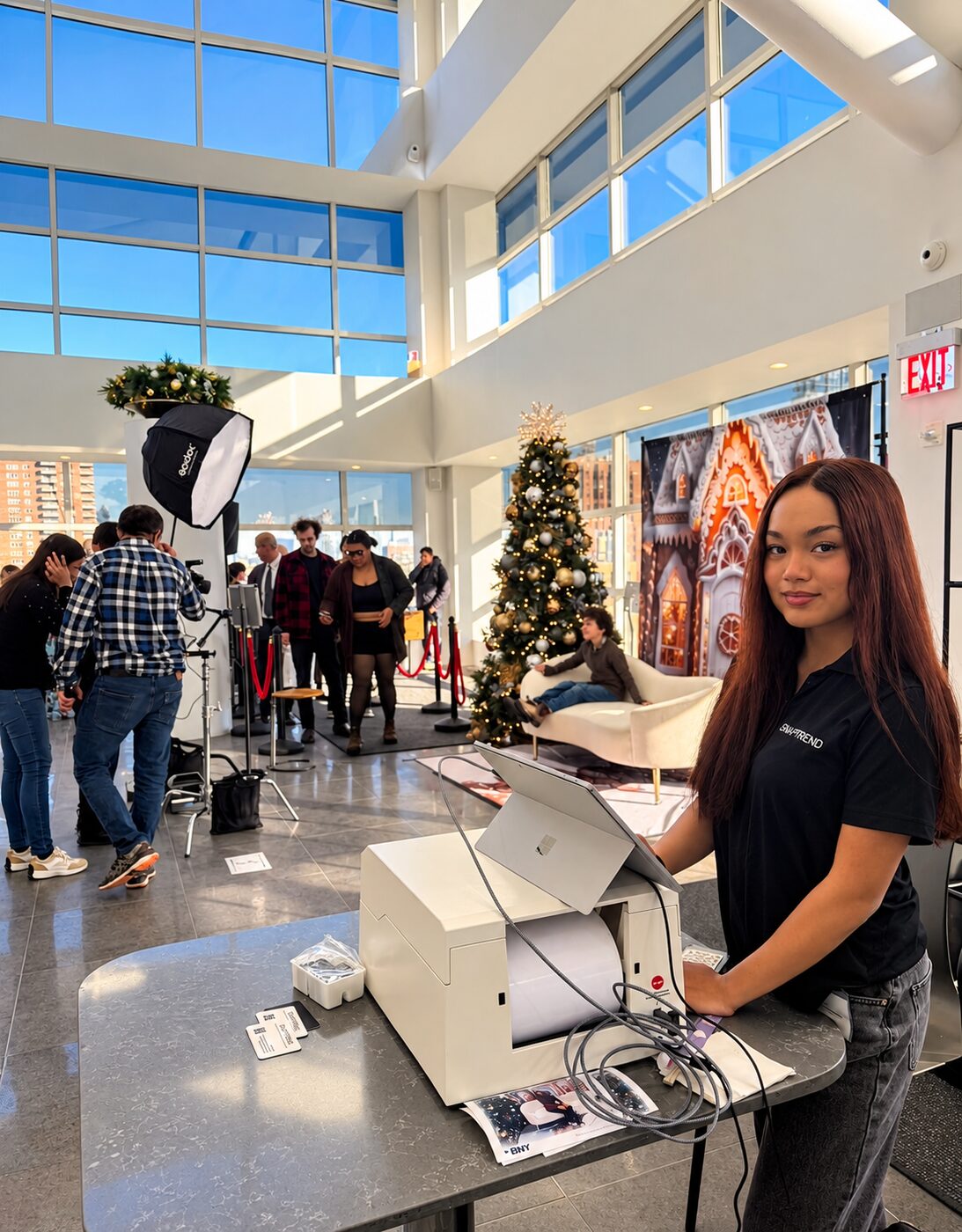 Snaptrend team member at the print station with a holiday photo booth in the background