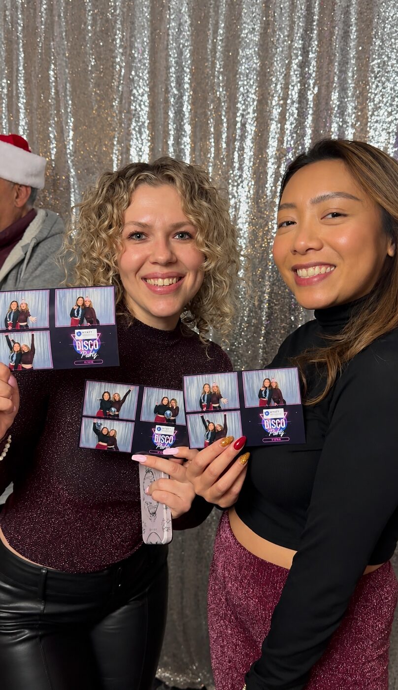 Two guests showing off their printed party photo strips