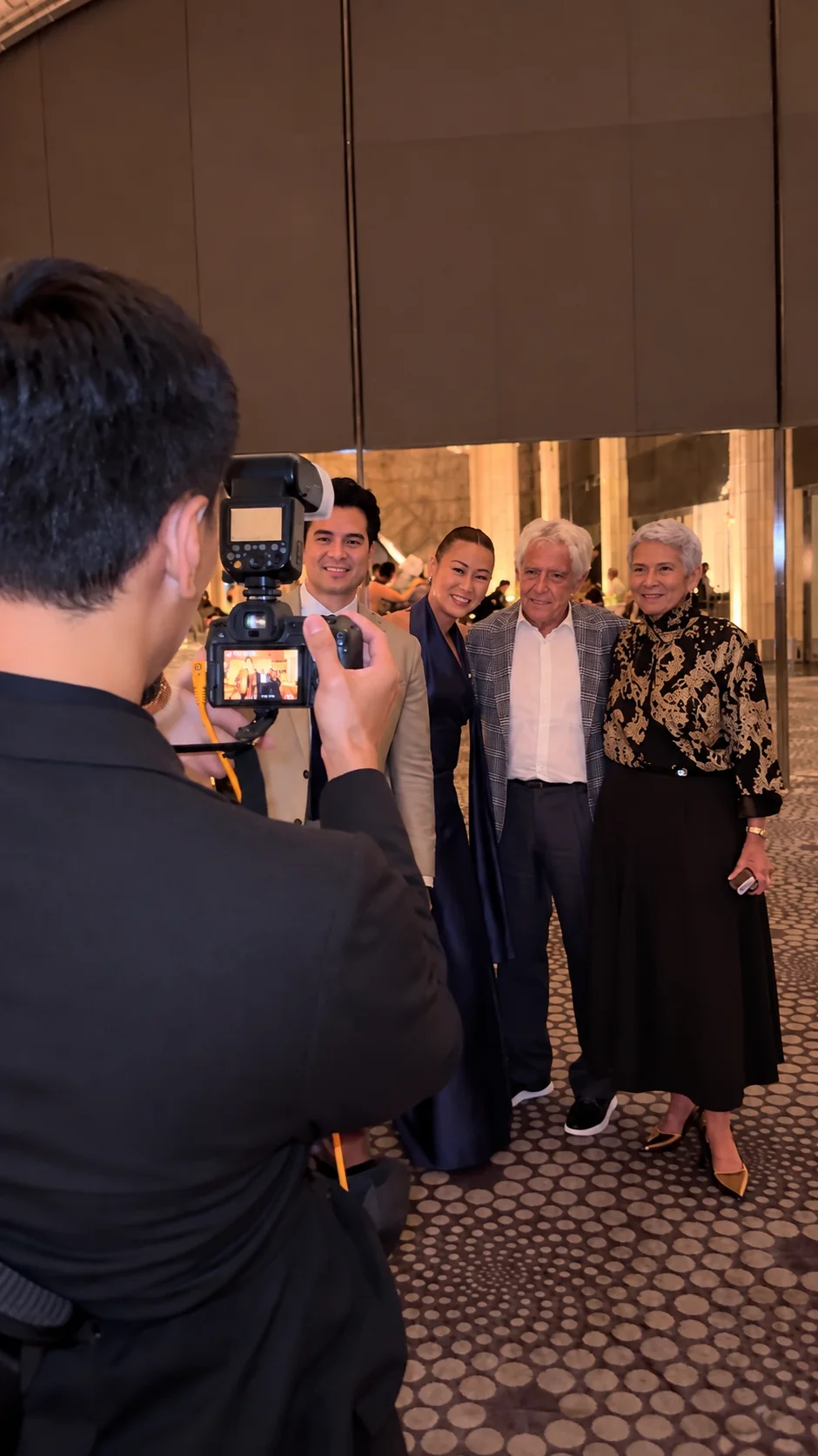 Photographer capturing a group of guests posing together at a gala