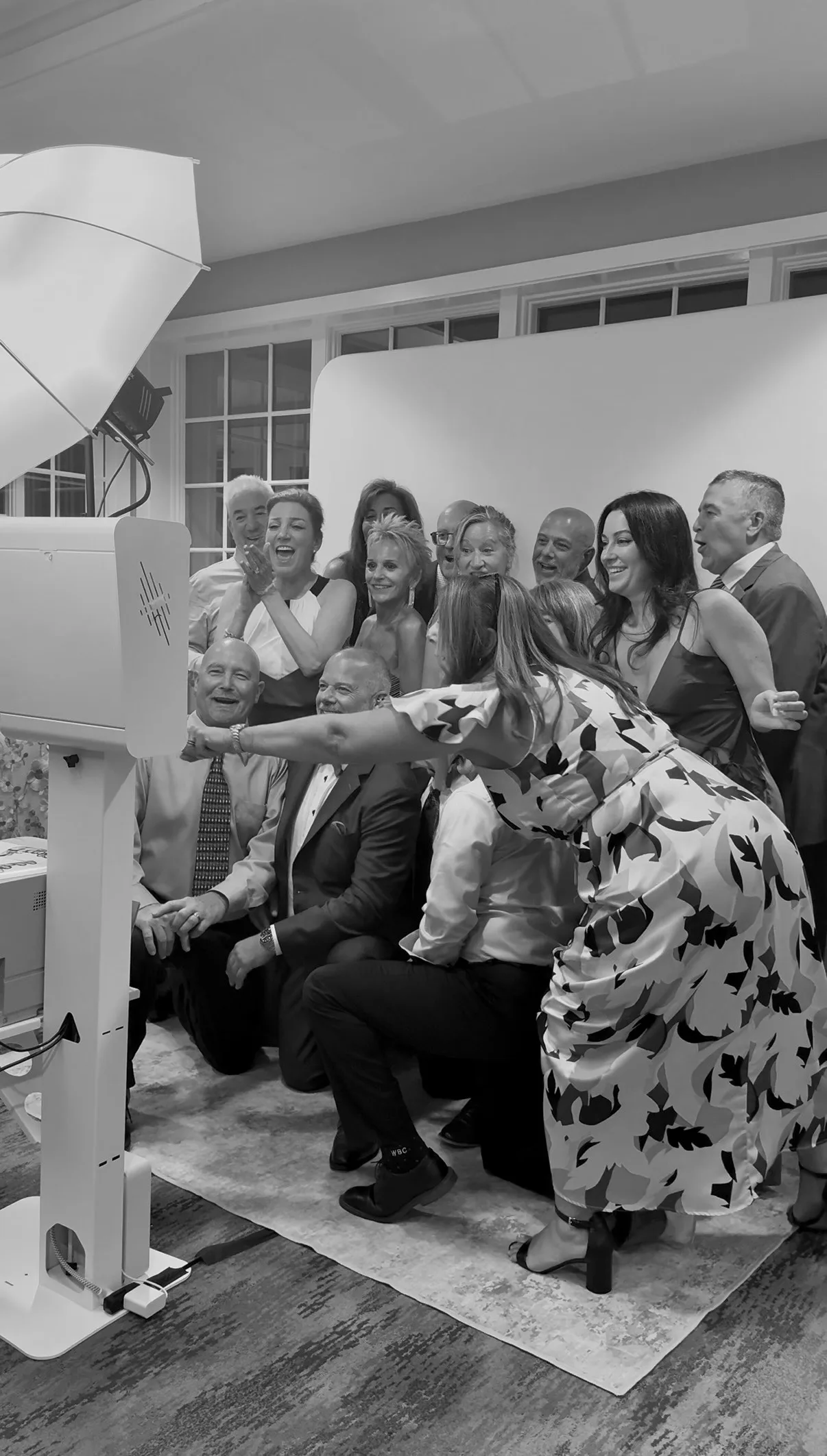A large group of guests lean in for a photo
