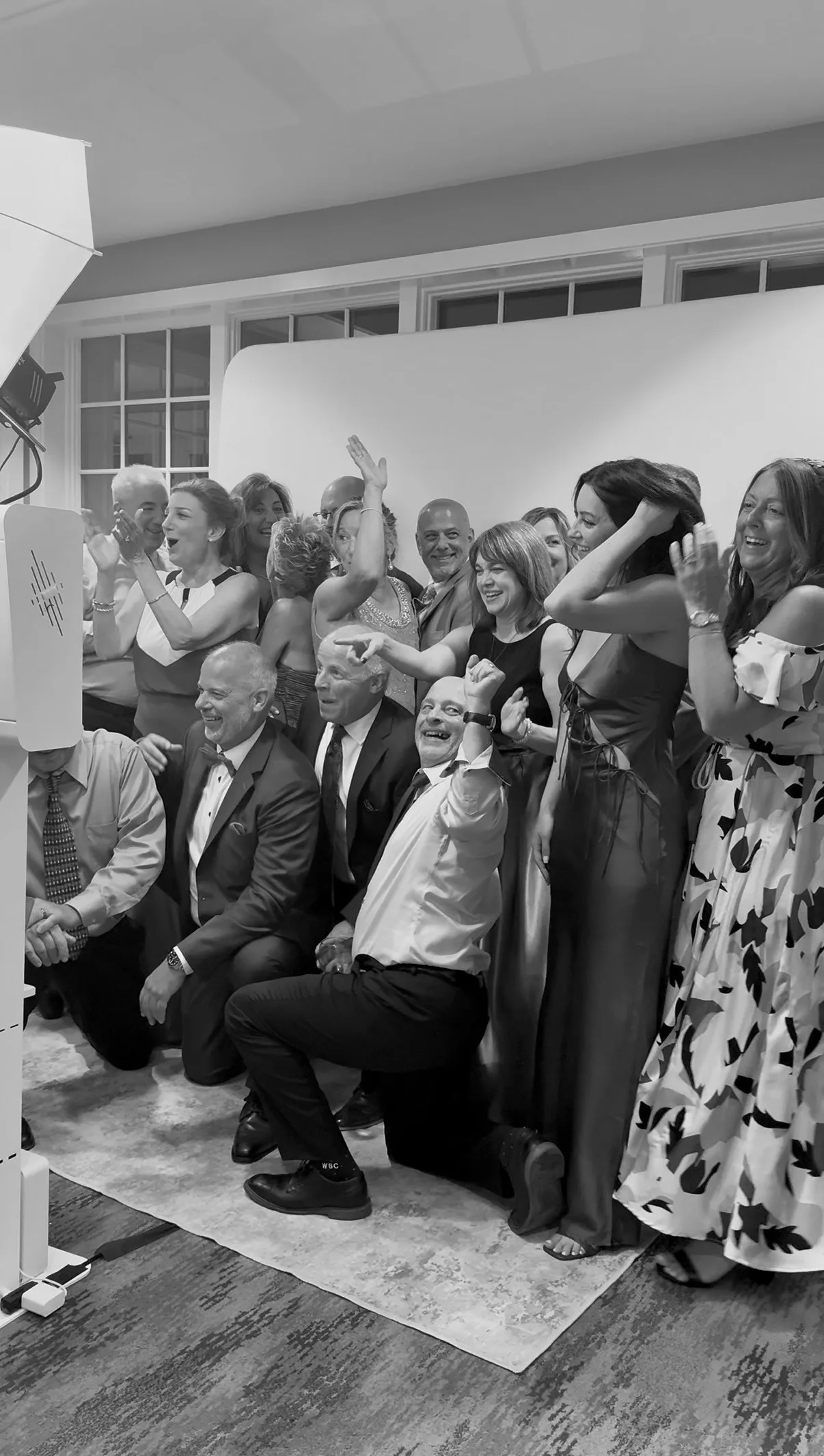 Wedding guests laugh while posing for a group shot