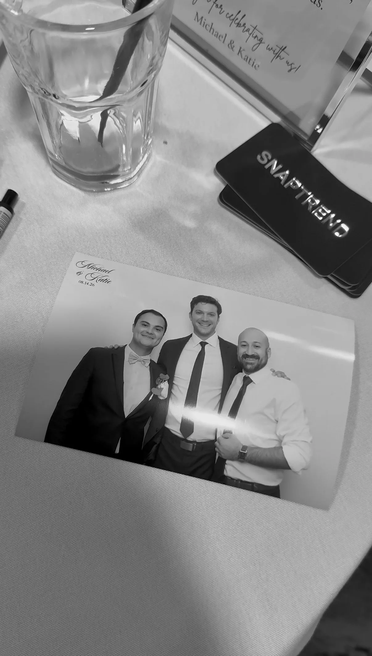 A printed photo with Michael and Katie’s wedding design on a table