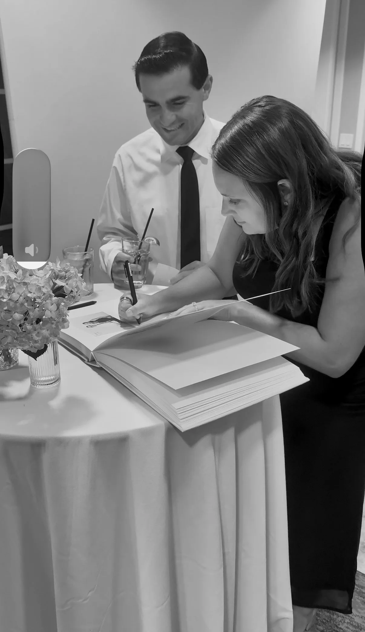Two guests look through printed photos at a table