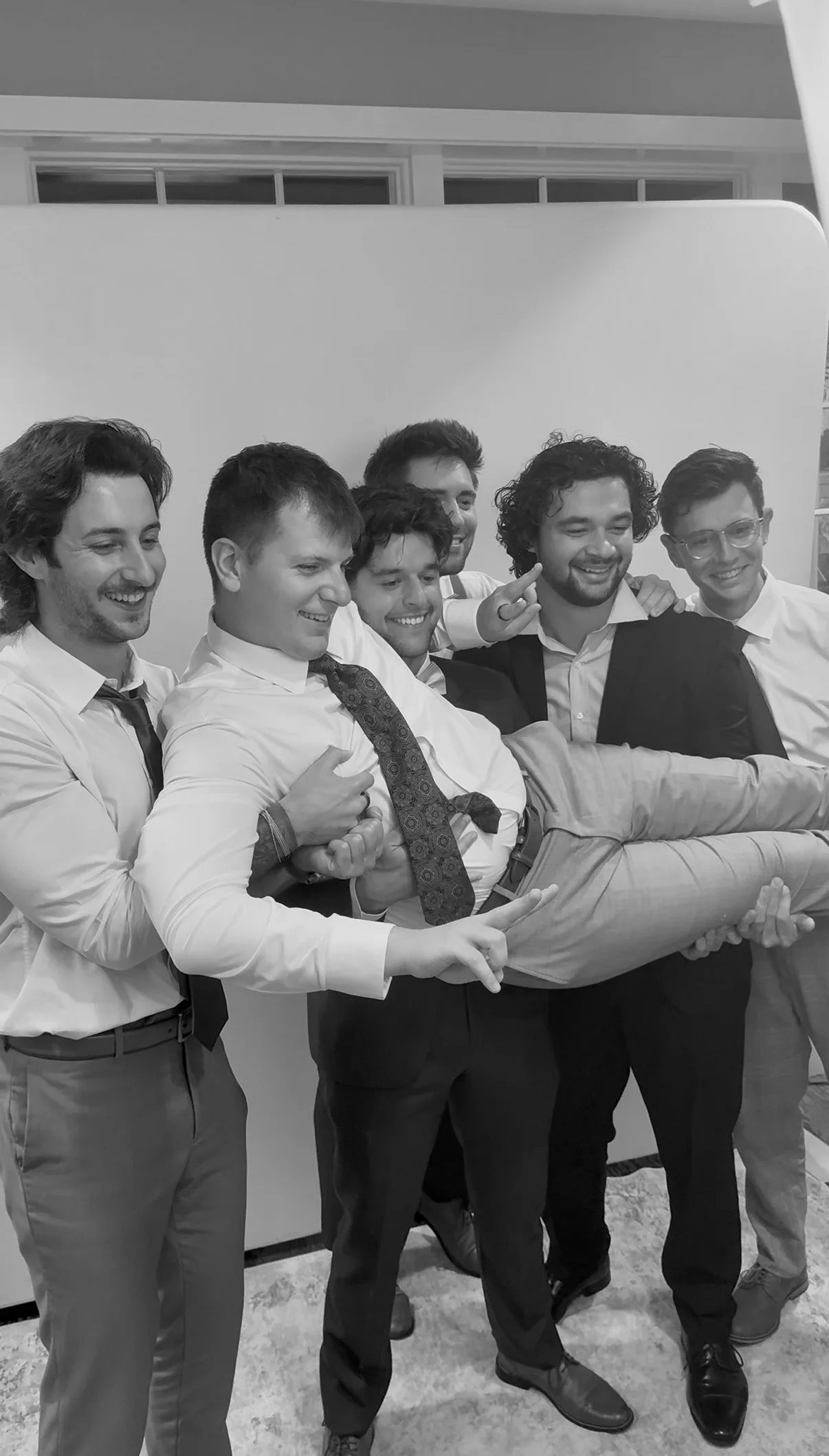 A group of guests reach together for a playful photo