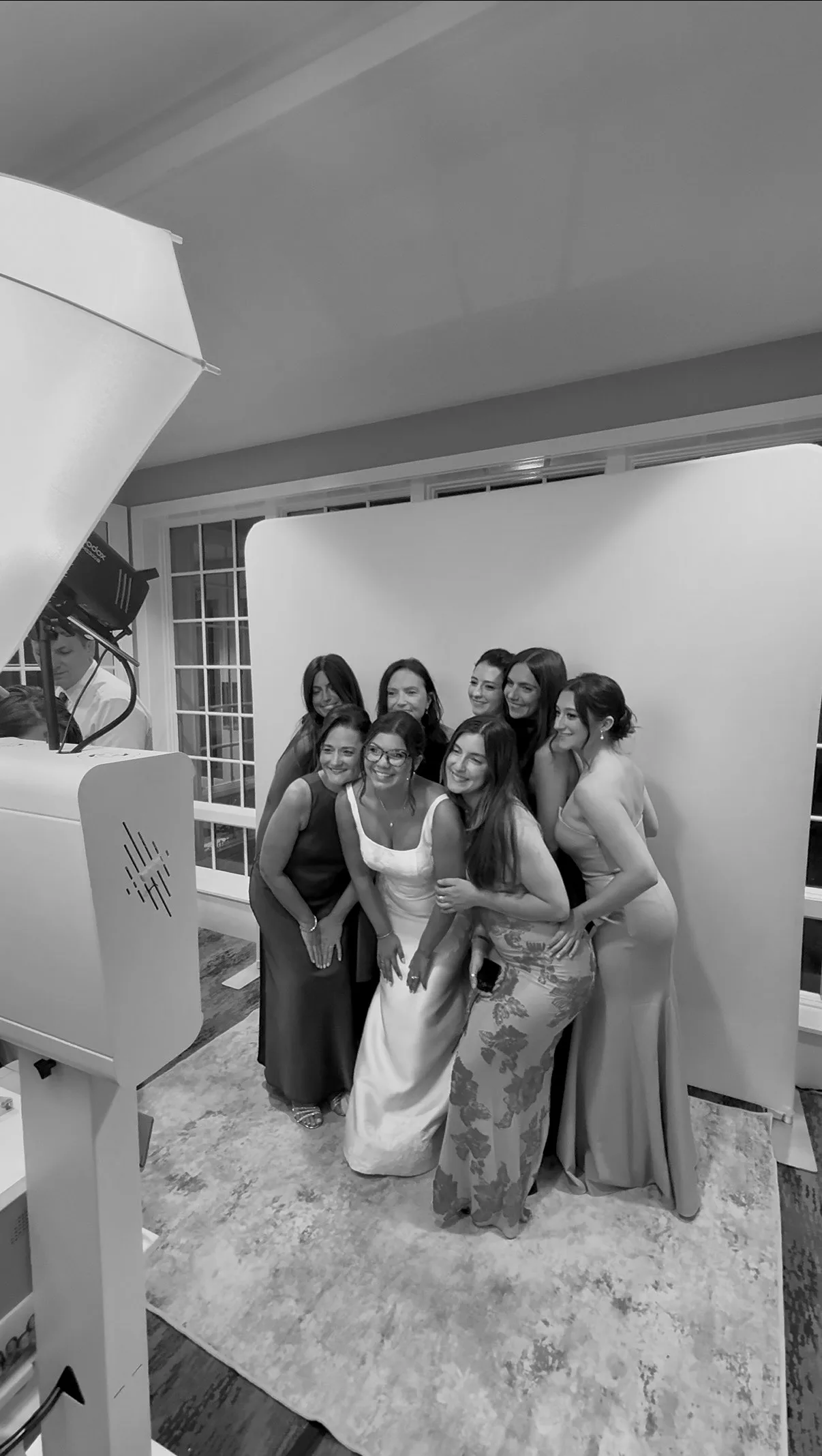 Wedding guests gather for a group photo beside the umbrella light