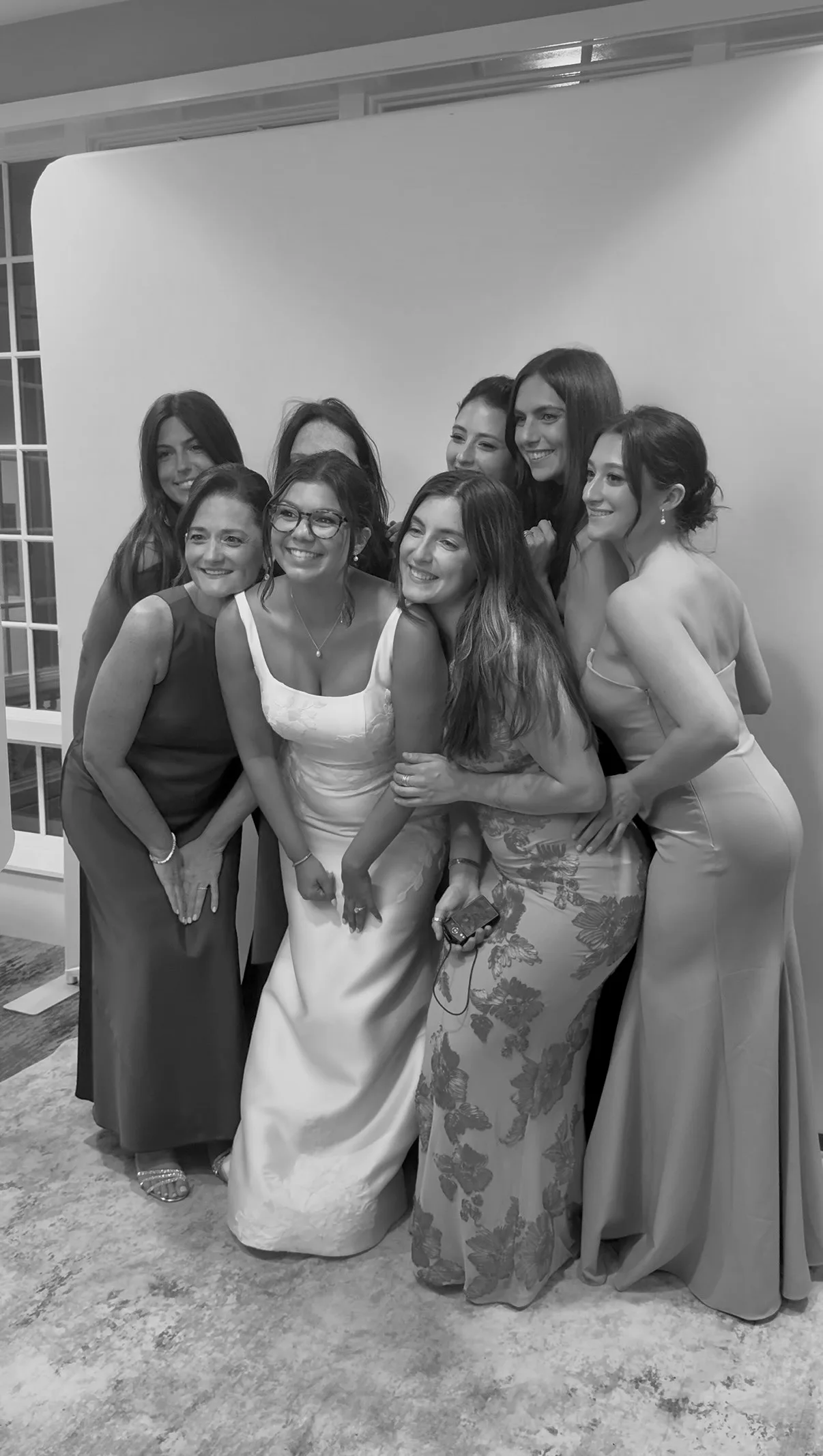 The bride and guests smile together at the photo booth