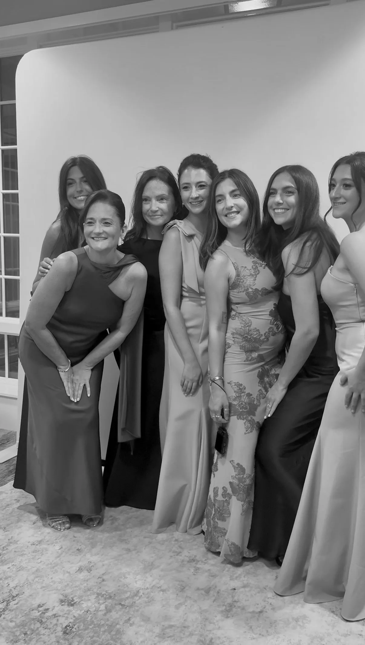 Wedding guests pose together in front of the booth backdrop