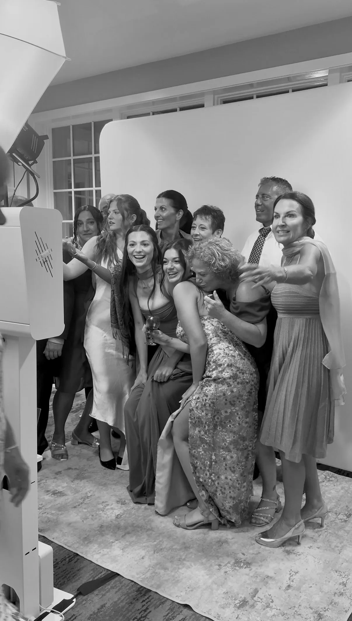 A group poses together at the booth while another guest looks on