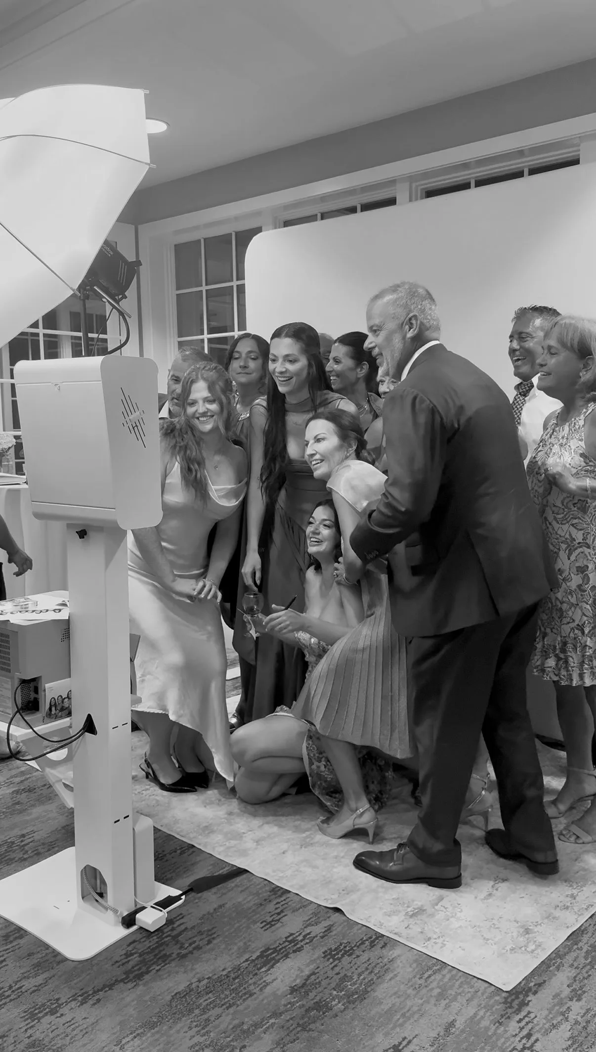 Wedding guests smile together beside the Glam Booth camera