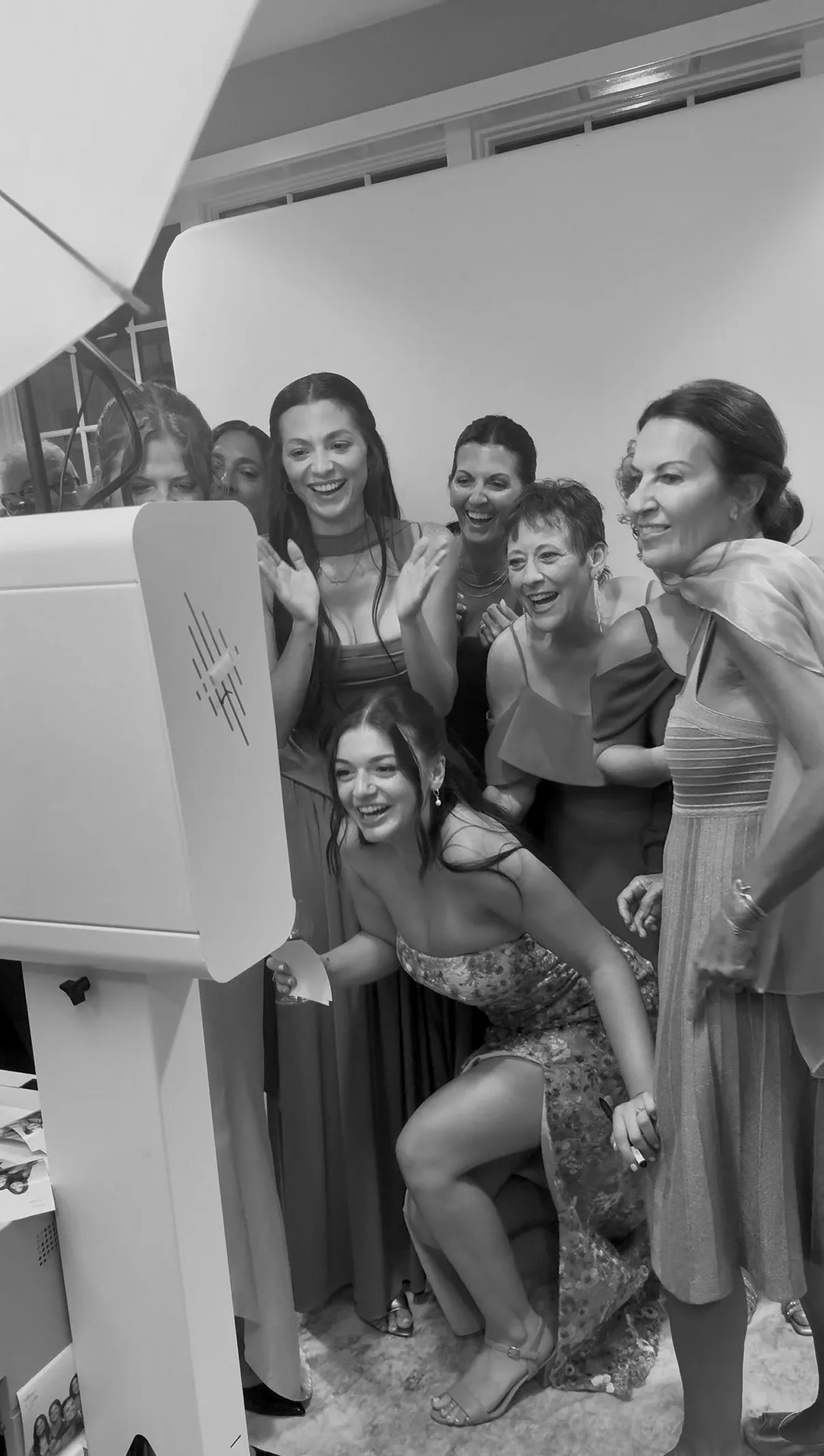 Guests lean in and smile at the booth