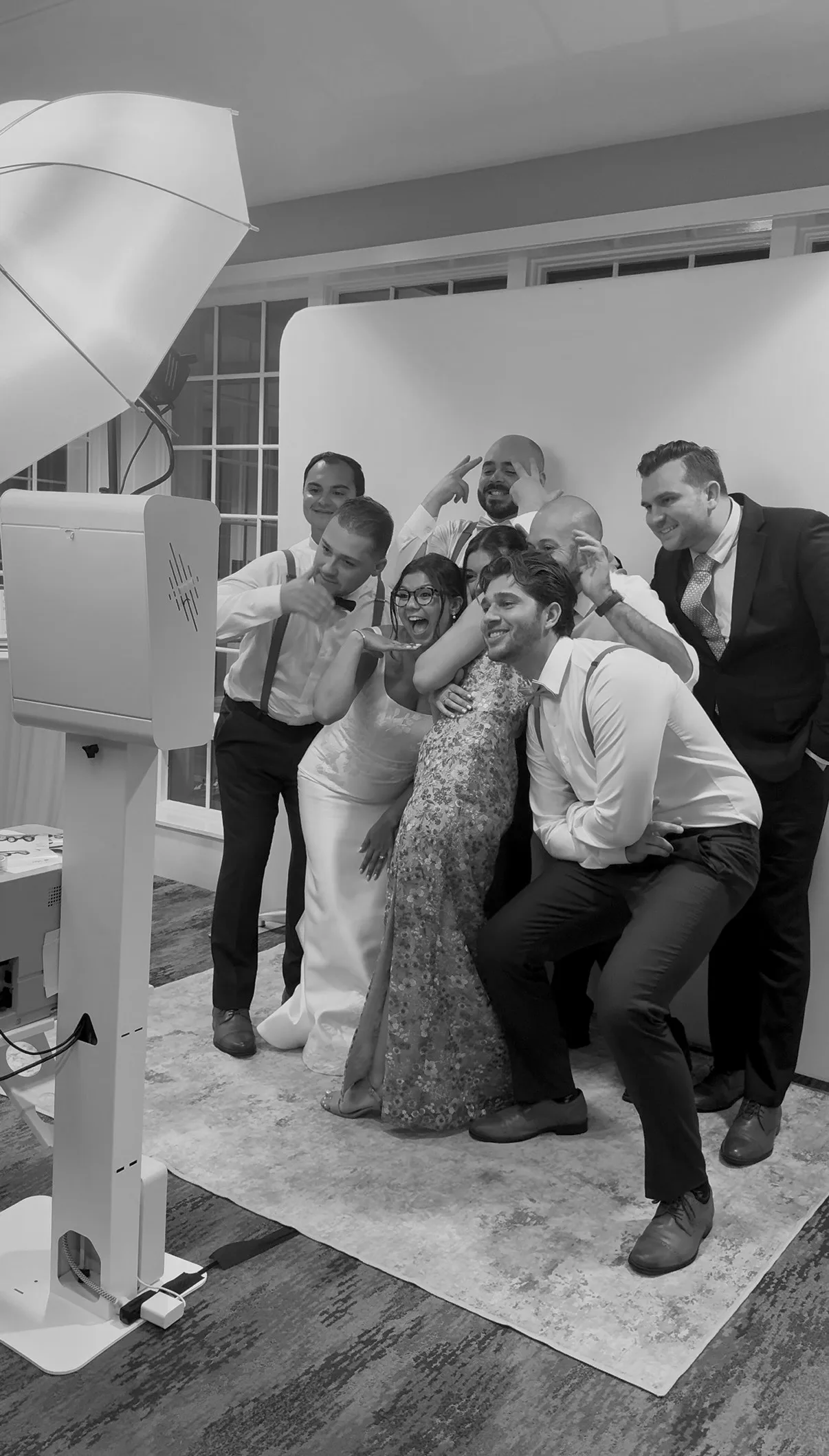Guests pose together at the booth under its umbrella light