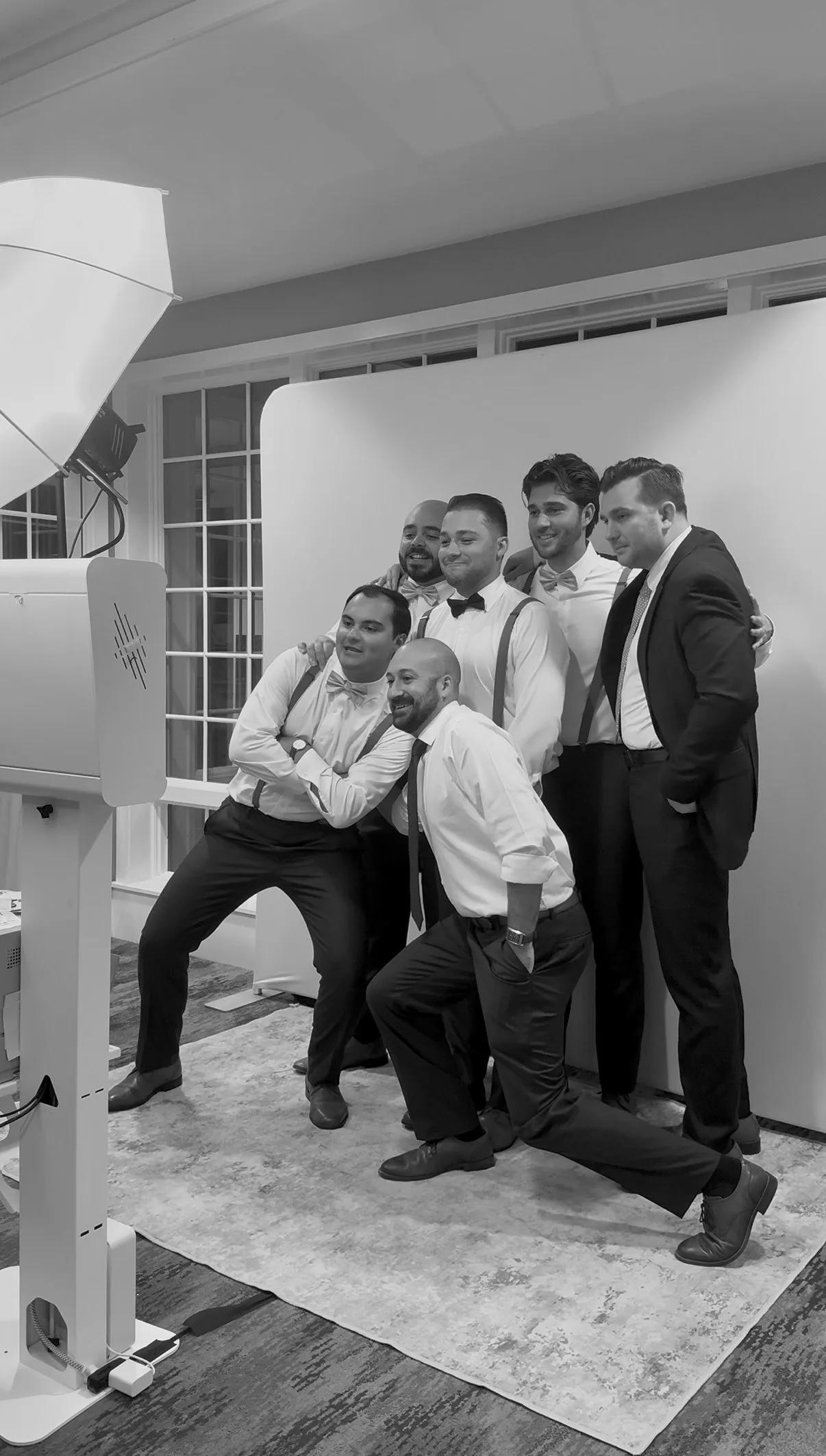 A group of guests pose playfully in front of the backdrop