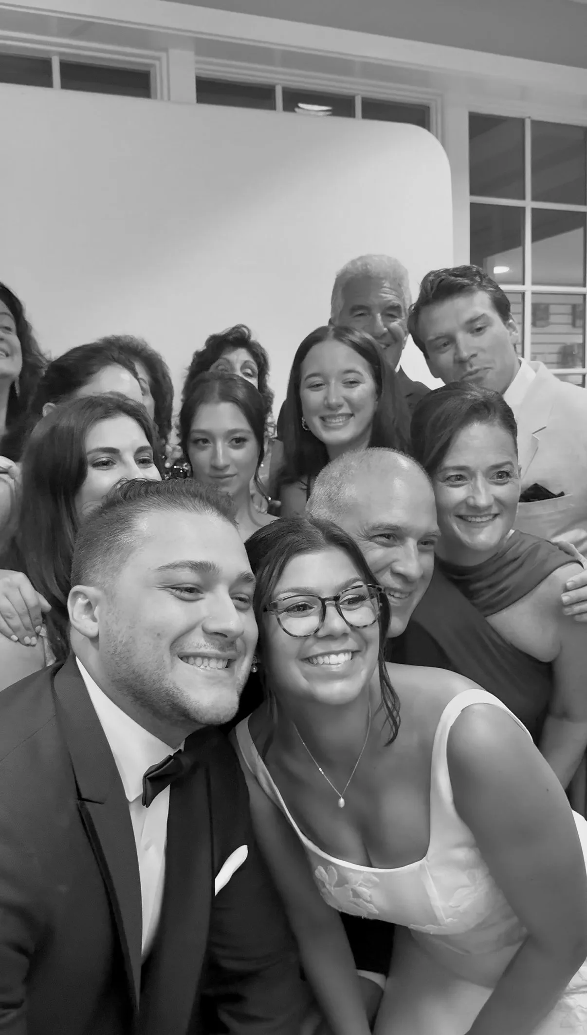 Katie and Mike smile with family and friends at the photo booth