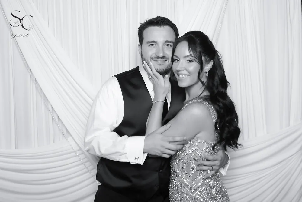 Cheyenne and Sean posing for a black-and-white Glam Booth portrait at their wedding
